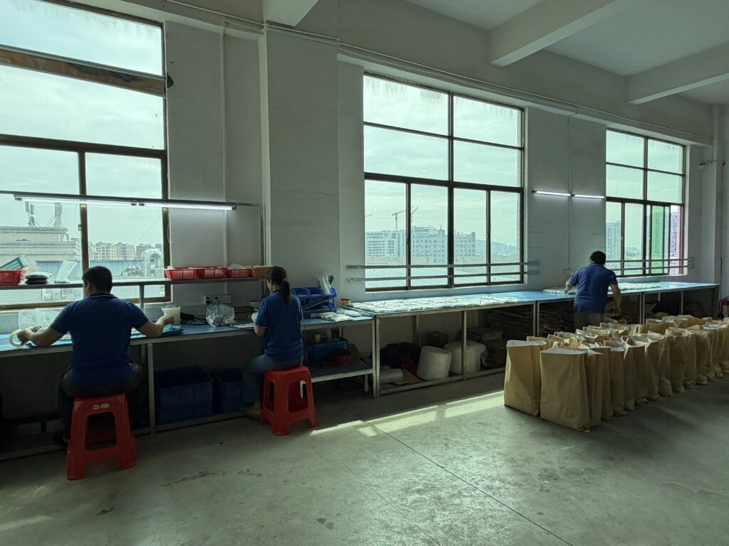  Factory packaging and visual inspection area with workers inspecting hardware products, clean workshop environment 